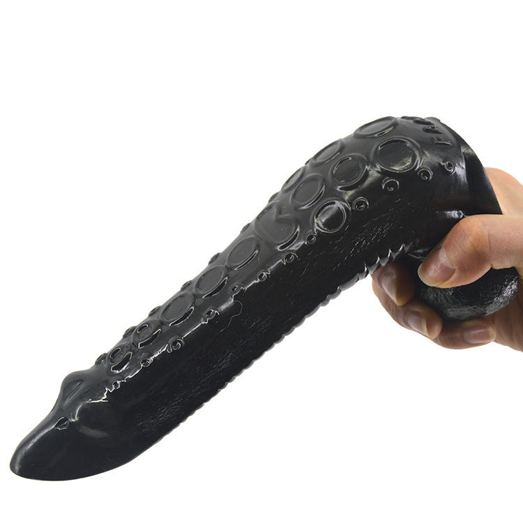 Black textured dildo held by a hand on a white background